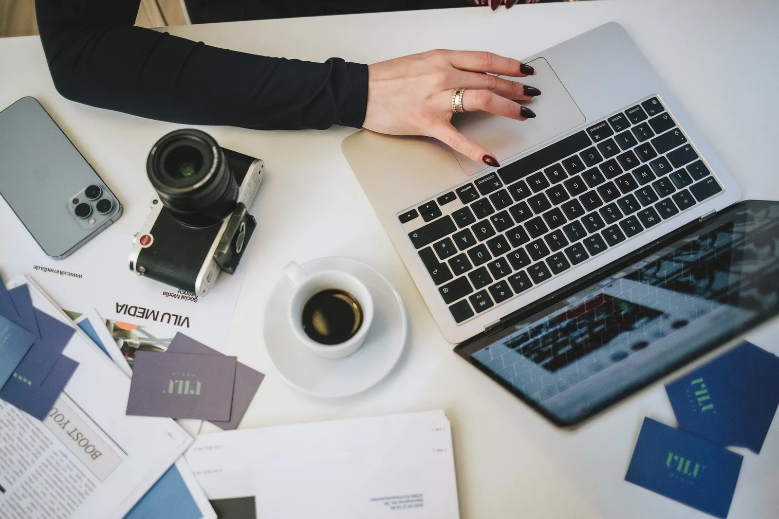 Schreibtisch mit Kamera, Laptop und Kaffee
